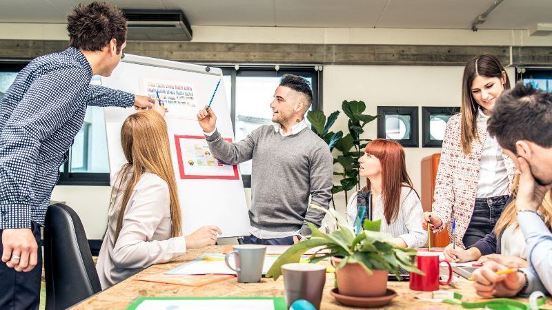 Das Bild zeigt ein Team von Menschen bei einem Meeting im Büro.